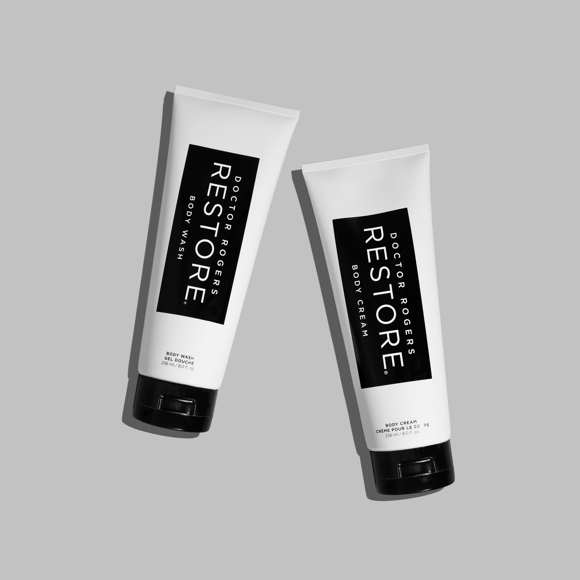 White and black 8 fl. oz sustainable, eco-friendly tubes of Doctor Rogers Body Duo including best natural antibacterial body wash for men and women on left and best body cream moisturizer for dry sensitive skin on right over grey background. 